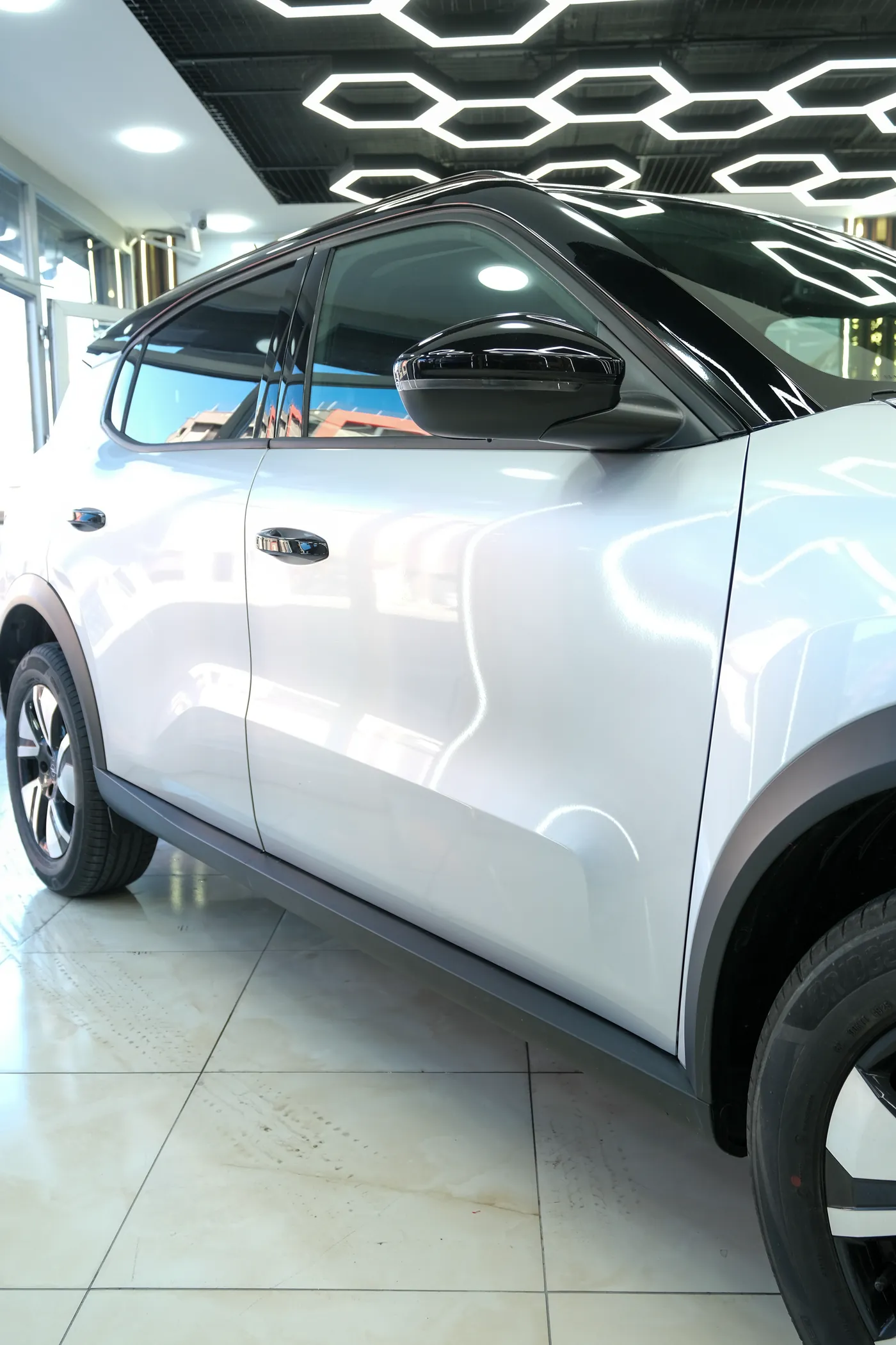Beyaz Togg yan görünüm, showroom zemininde